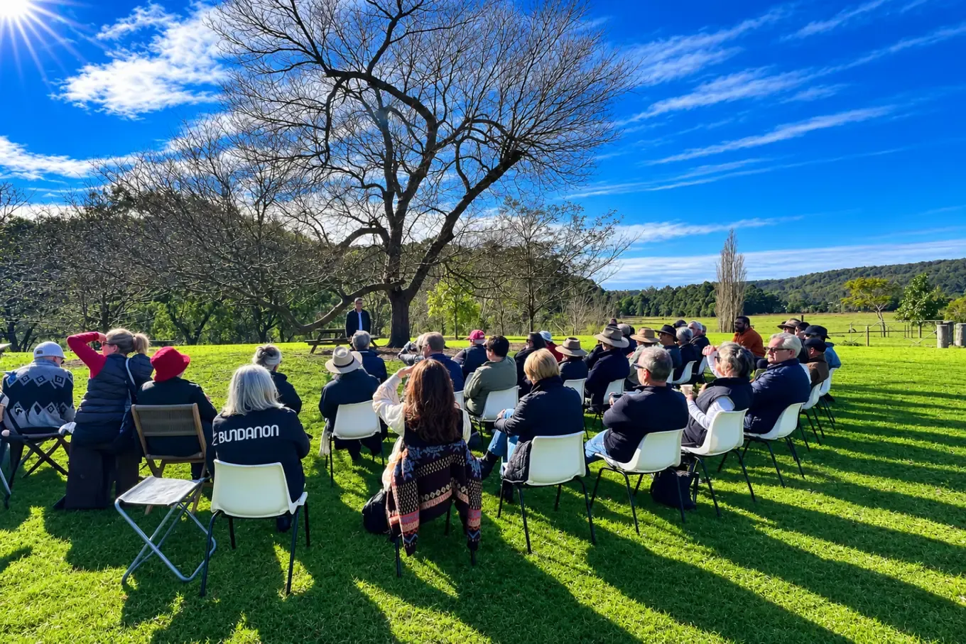 The audience seated on the lawn in front of the Bundanon homestead, hills behind